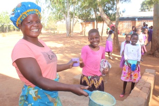 An image of a volunteer cook serving school meals to children