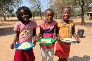 Image of three children holding their school meals