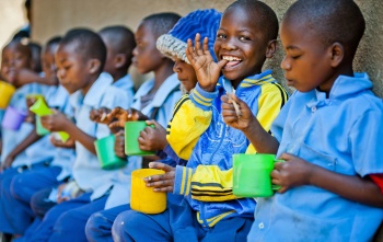 Children eating mugs of porridge