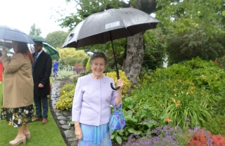 Mary's Meals supporter standing in garden under umbrella