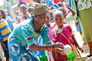 Volunteer cook serving food in Malawi