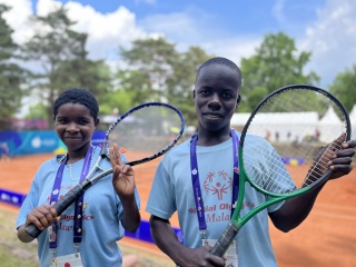 Hannah and Patrick holding up tennis rackets