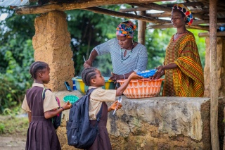 Children being served Mary's Meals by two volunteers in Liberia