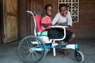 A young girl, Flora, sits in her wheelchair, while her friend Olive is next to her