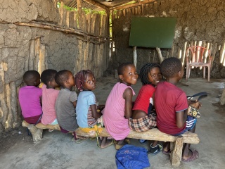 Children sitting on a bench in a classroom in Mozambique