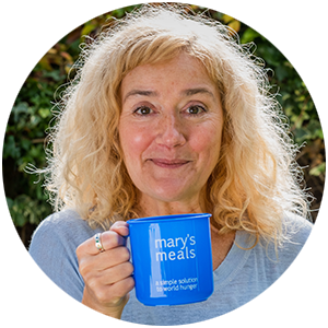 An image of Sophie Thompson holding a Mary's Meals mug