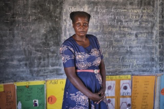 A teacher at Zhakata School, Fortunate, stands in her classroom.